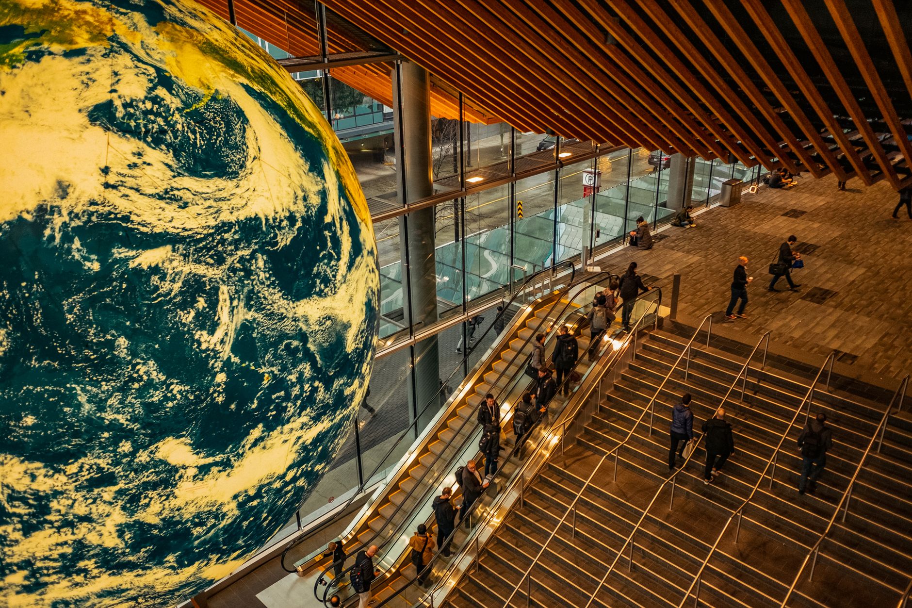 globe over people on stairs and escalators